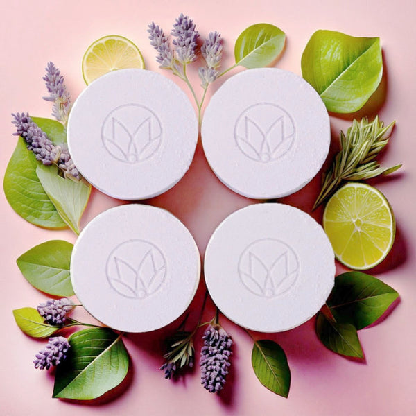 Four Musee Lavender & Lime shower steamers with a logo, surrounded by green leaves and lavender flowers & limes on a pink background