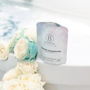 Bathorium Midnight Superbloom Bath Soak Sitting On The Edge Of Tub with Bath Soak in Water | Build A Luxury Custom Gift Box for Women with Luxe & Bloom