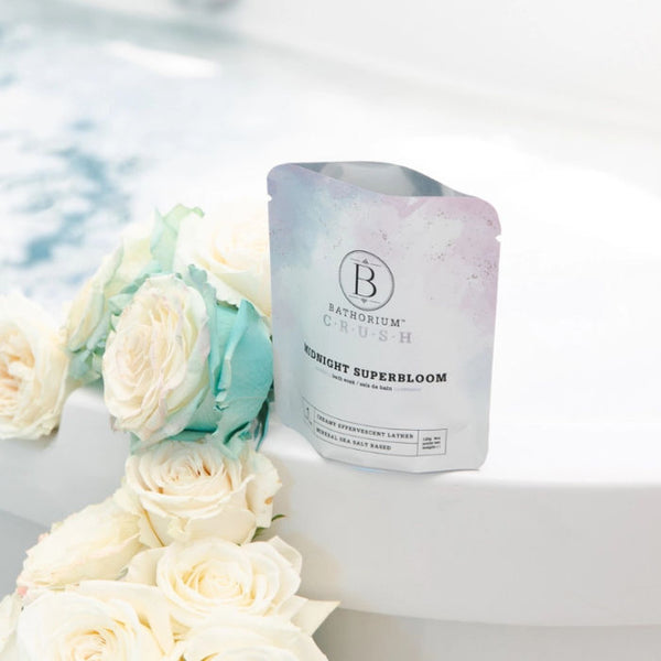 Bathorium Midnight Superbloom Bath Soak Sitting On The Edge Of Tub with Bath Soak in Water | Build A Luxury Custom Gift Box for Women with Luxe & Bloom