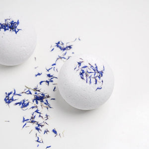 Bathorium white Snooze bath bombs with purple flowers on a white background