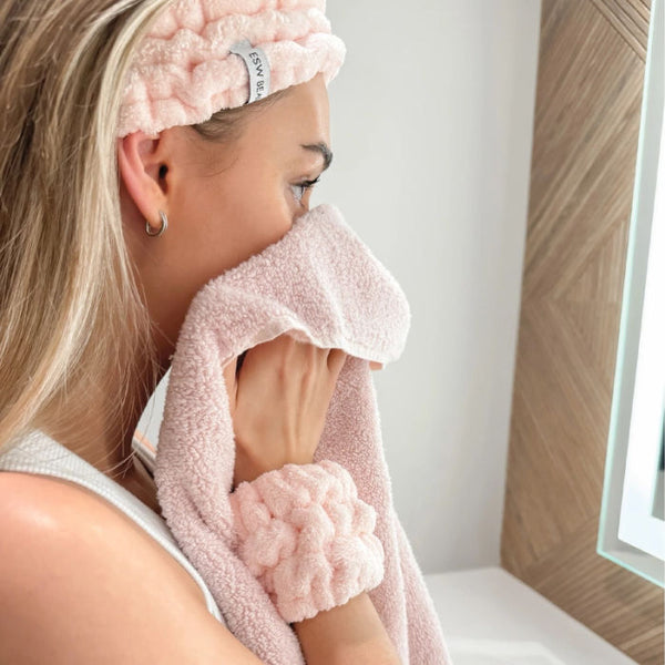 Woman using ESW Beauty Pink Skincare Headband & Wrist Bands in a bathroom | Build A Luxury Custom Gift Box for Women with Luxe & Bloom