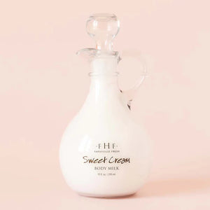 Glass bottle of F.H.F. Sweet Cream Body Milk on a pink background | Build A Luxury Custom Gift Box For Women with Luxe & Bloom