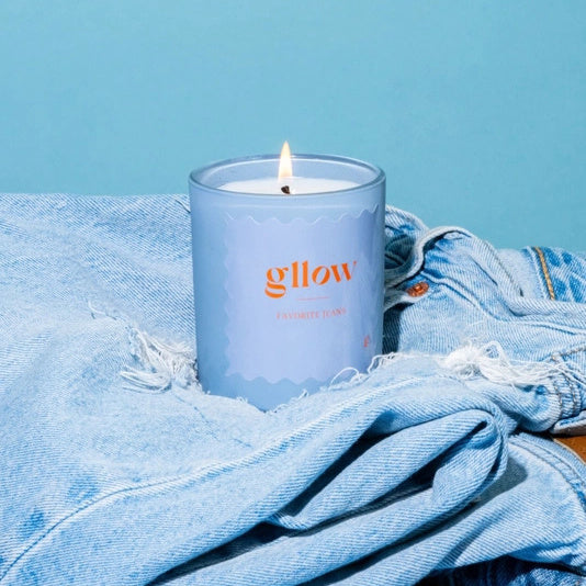 Glow Favorite Jeans Candle in a blue container on denim jeans with a blue background | Build A Luxury Custom Gift Box for Women with Luxe & Bloom