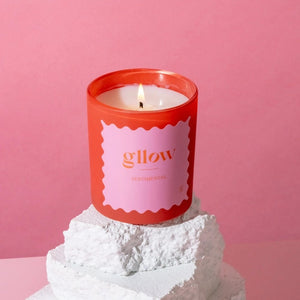Glow Sentimental Scented candle with a pink label on a white base against a pink background | Build A Luxury Custom Gift Box for Women with Luxe & Bloom
