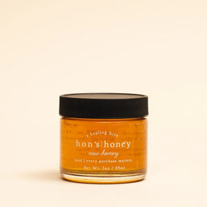 Jar of Hon's Raw Honey with a black lid on a beige background | Build A Custom Luxury Gift Box for Women with Luxe & Bloom