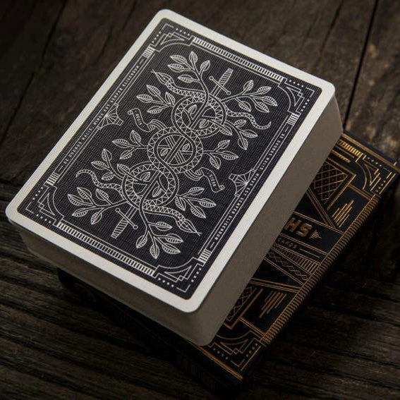 Theory 11 Monarch playing cards with intricate design on a wooden surface