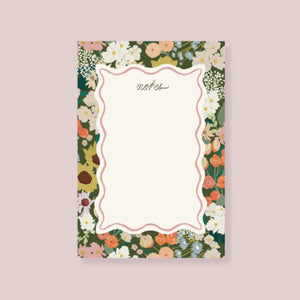 Amy Heitman Flower Market notepad with a cream center writing area framed by a multicolor floral border, shown on a solid pale lavender background | Build A Luxury Custom Gift Box for Women with Luxe & Bloom