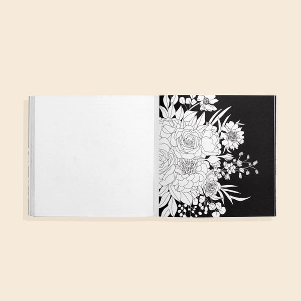 Coloring book open to a page with a floral design on a beige background
