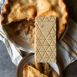 Compartés Apple Pie Chocolate Bar sitting on an apple pie with a piece missing | Build A Custom Luxury Christmas Gift Box with Luxe & Bloom