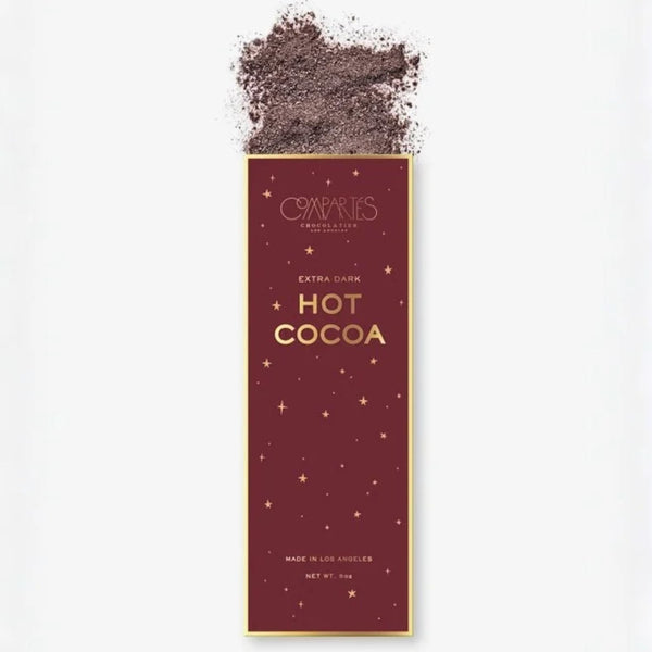 A tall rectangular package of Compartés Chocolate Extra Dark Hot Cocoa, featuring a deep burgundy background with gold text and star details, with cocoa powder spilled at the top against a white background.