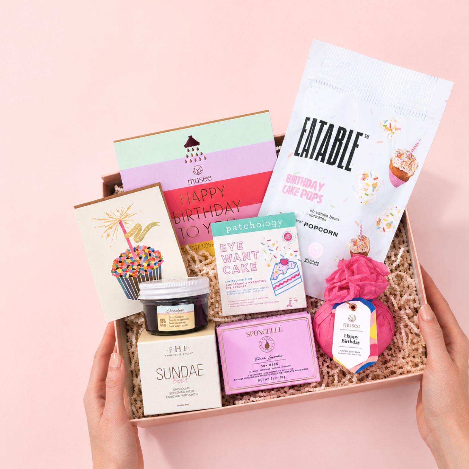 Hands holding Deluxe Birthday Treat Gift Box with Birthday Cake Themed Treats on a blush background | Luxury Curated Gift Boxes for Women from Luxe & Bloom