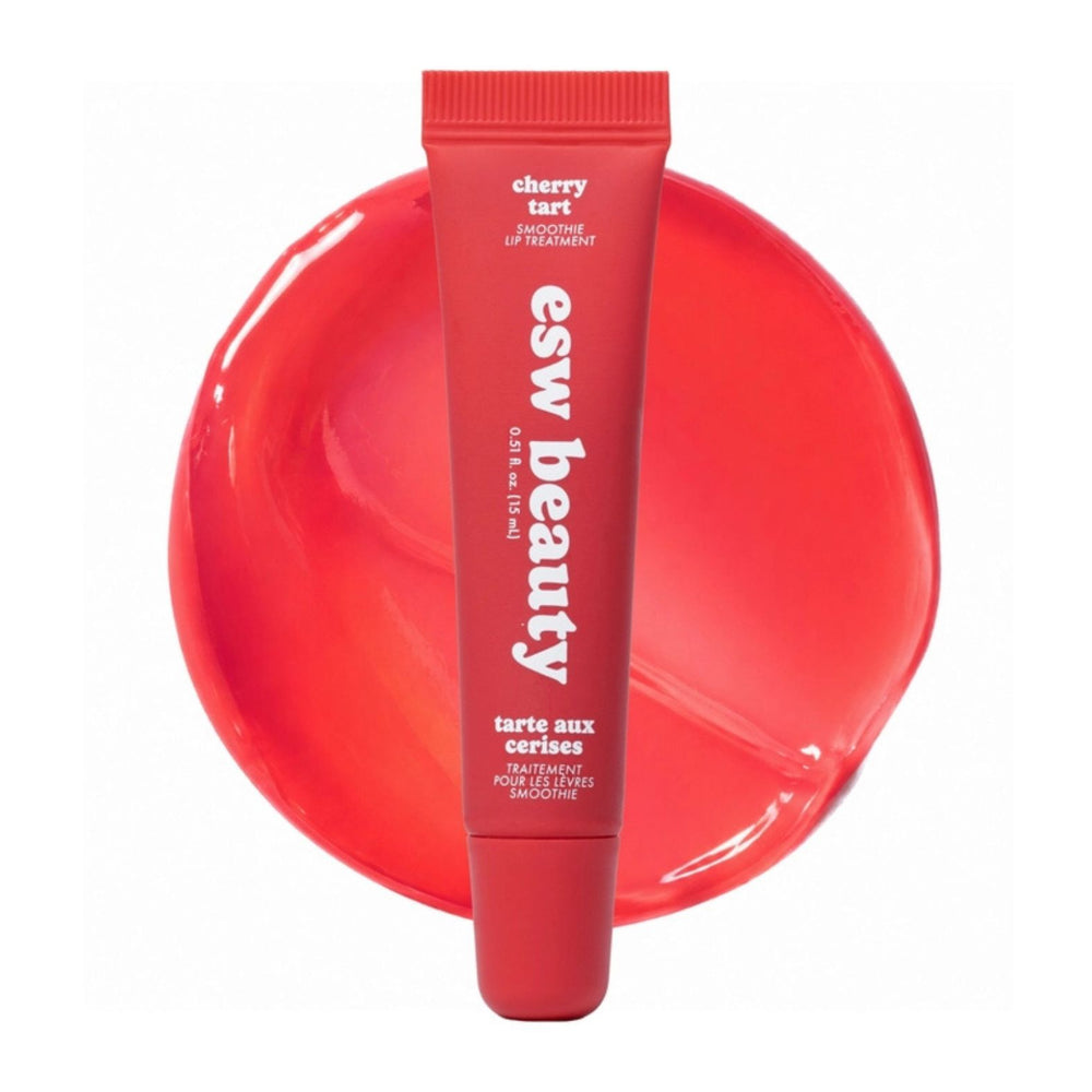 A red squeeze tube of esw beauty cherry tart lip treatment standing in front of a matching red circular swatch on a white background.
