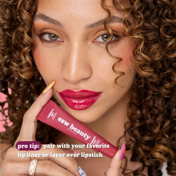 Woman holding ESW Beauty Raspberry Acai Smoothie Lip Treatment with deep berry colored lip gloss on | Build A Luxury Custom Gift Box for Women with Luxe & Bloom