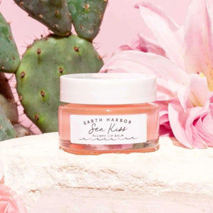 Pink lip balm jar with 'Earth Harbor' Sea Kiss Plumpy Lip Balm against a floral and cactus background | Build A Luxury Custom Gift Box for Women with Luxe & Bloom