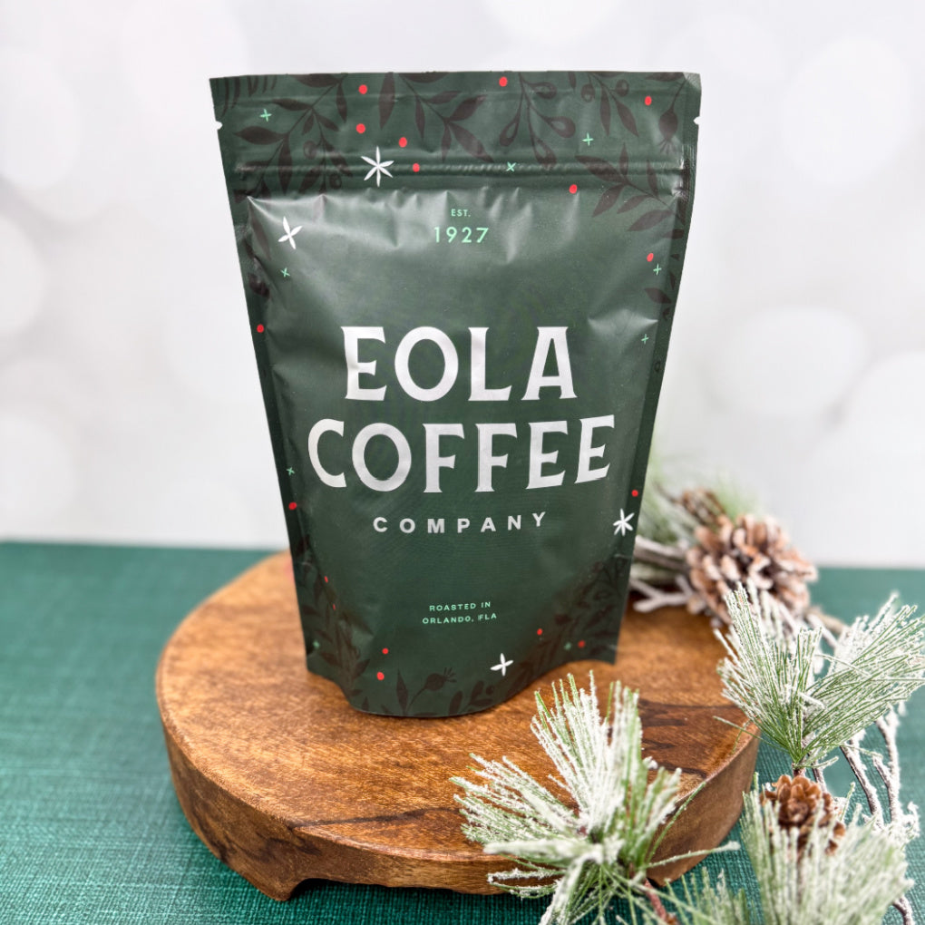 Eola Coffee Company Holiday bag on a wooden stand with decorative elements