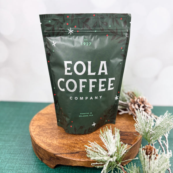Eola Coffee Company Holiday bag on a wooden stand with decorative elements
