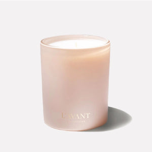 A Blushed Bergamot frosted glass jar candle with a single wick, featuring a soft blush pink color and gold foil branding that reads 'L'AVANT COLLECTIVE'. The candle is set against a solid off-white background with a soft shadow cast to the right.