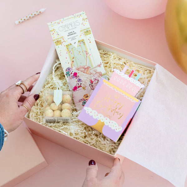 Petite Birthday Treat Luxury Curated Gift Box for Women on a pink background with balloons and candles