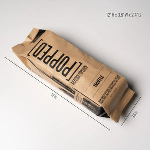 A single bag of Popped Artisan Popcorn in the Truffle flavor, packaged in brown kraft paper with black printed text, photographed on a clean white background with dimensions: 12" x 3.6" x 2.4" | Build A Luxury Custom Gift Box with Luxe & Bloom