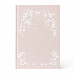 Selah Publications The Lainey Notebook: A linen colored hardcover notebook with a white ornate stitched floral border and the word 'notes' in small gold script near the upper center, shown on a clean white background.