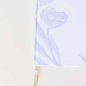 A close up of Selah Publications The Langley Notebook with blue painted flowers and gold lettering on an off-white linen cover with gold ribbon | Build A Christian Custom Gift Box for Women with Luxe & Bloom