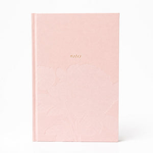 Selah Publications The Polly Blair Notebook with a blush pink hardcover notebook with a subtle embossed floral pattern and the word 'notes' printed in small gold text near the top center, shown on a clean white background.