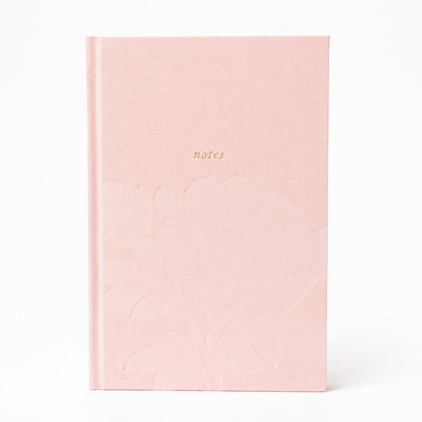 Selah Publications The Polly Blair Notebook with a blush pink hardcover notebook with a subtle embossed floral pattern and the word 'notes' printed in small gold text near the top center, shown on a clean white background.