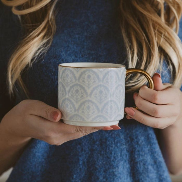 Woman holding a blue fan patterned fine bone china mug with a gold handle