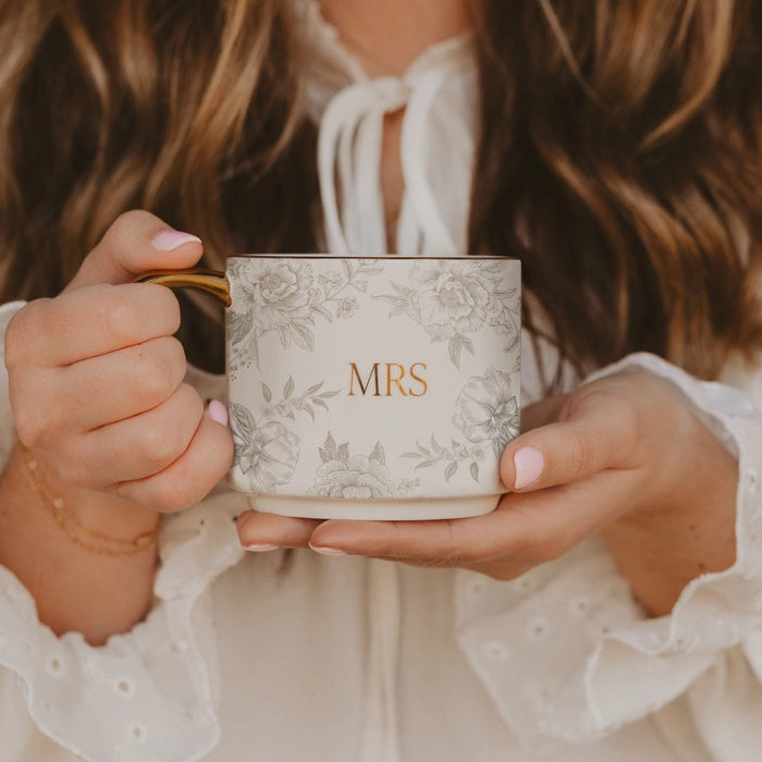 Woman holding a mug with 'MRS' on it, wearing a white lace garment | Sweet Water Decor Mrs Coffee Mug | Build. A Luxury Custom Gift Box for Women with Luxe & Bloom
