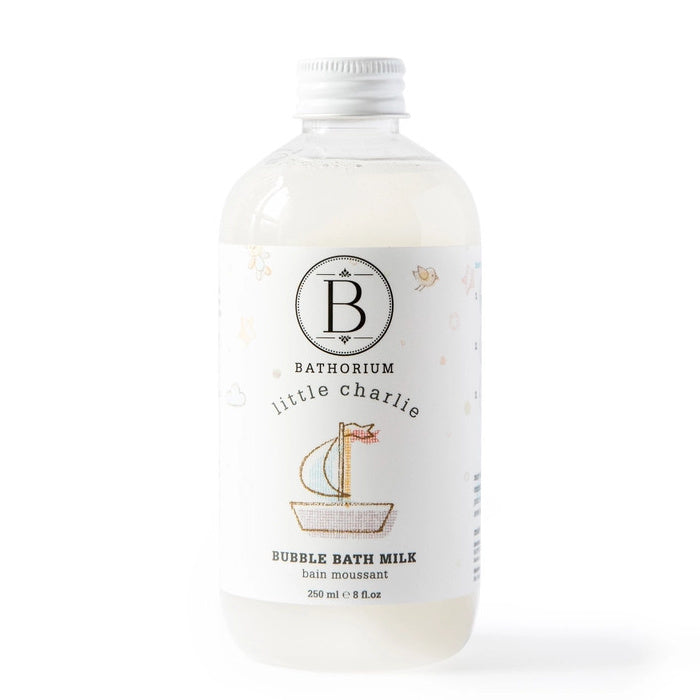 Two bottles of Bathorium Little Charlie bubble bath milk with bubbles on a white plate with a white background