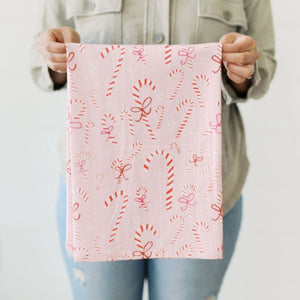 Person holding a Doe A Dear pink towel with red candy cane patterns against a neutral background | Build A Custom Christmas Gift Box with Luxe & Bloom
