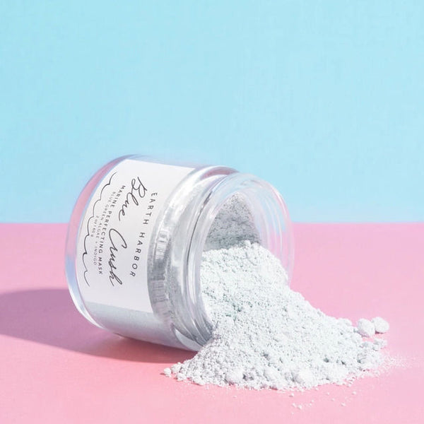Open Jar of Earth Harbor Naturals Blue Crush Marine Perfecting Mask spilling out onto a pink and blue background