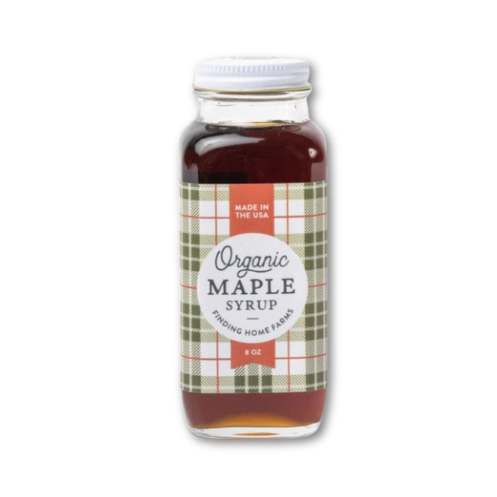 Bottle of Finding Home Farms organic maple syrup in limited edition Holiday bottle with a label on a white background