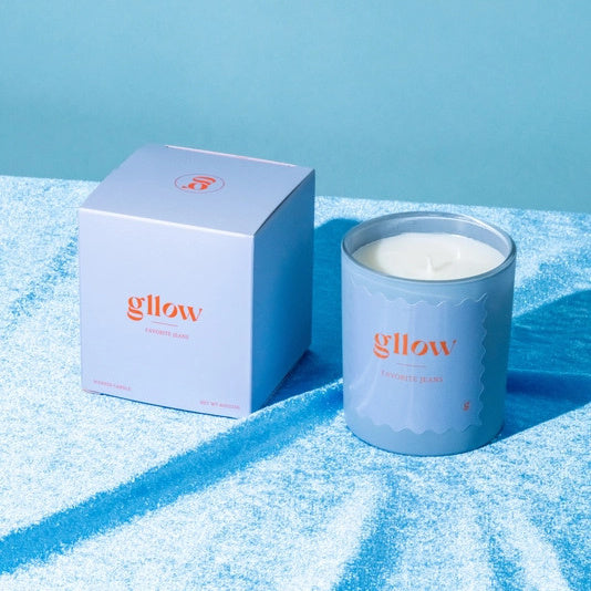 Glow Favorite Jeans Candle in a blue container on denim jeans with a blue background | Build A Luxury Custom Gift Box for Women with Luxe & Bloom