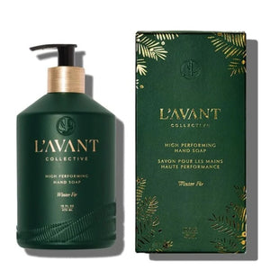 L'AVANT Collective Winter Fir high performing hand soap bottle in dark green with a gold pump, shown next to its matching green and gold packaging box on a white background.
