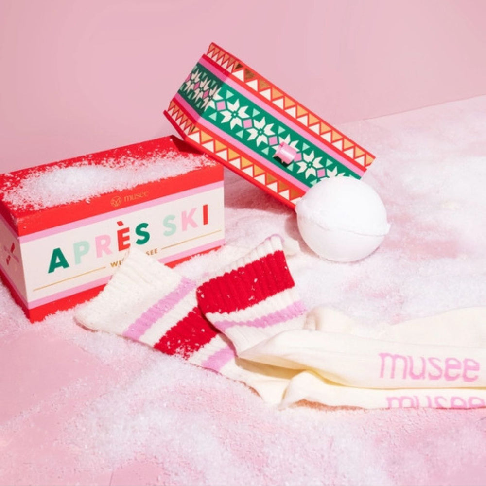 Musee Apres Ski bath balm & sock gift set with a decorative box on a pink background