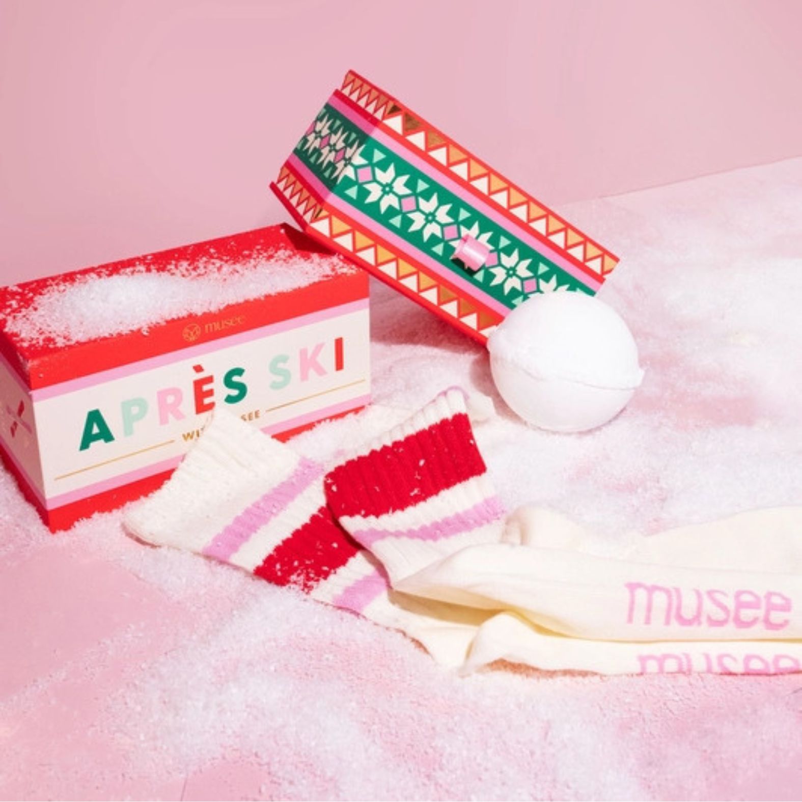 Musee Apres Ski bath balm & sock gift set with a decorative box on a pink background