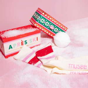Musee Apres Ski bath balm & sock gift set with a decorative box on a pink background