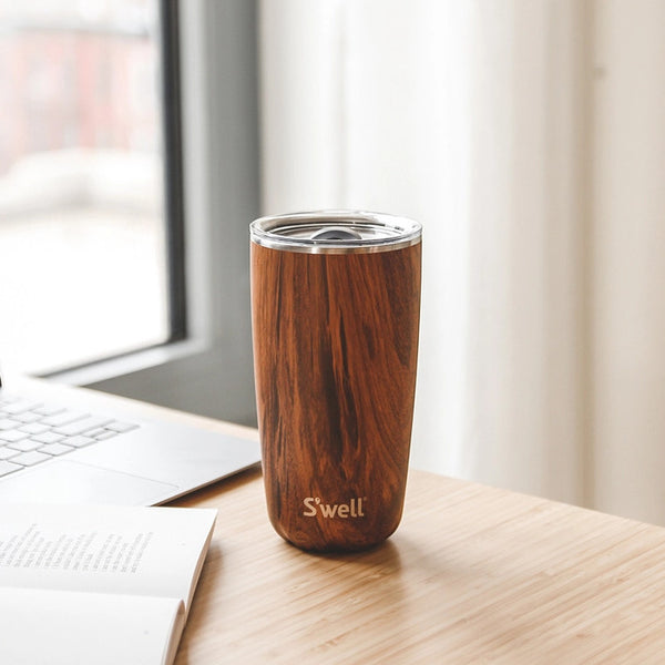 Wooden S'well tumbler on a desk with a laptop in the background