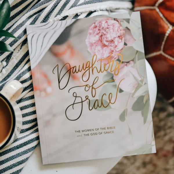 The Daily Grace Co. Daughters of Grace Bible Study sitting on a table with coffee and a throw blanket | Build A Luxury Christian Custom Gift Box for Women with Luxe & Bloom