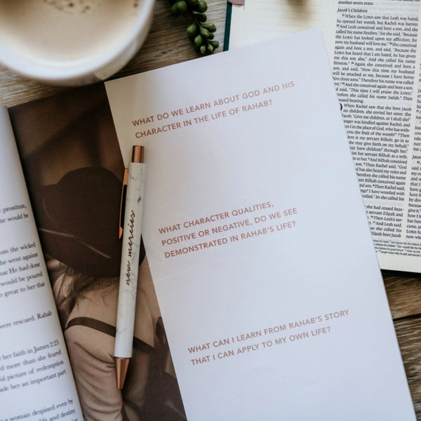 The Daily Grace Co. Daughters of Grace Bible Study open on a table with a pen | Build A Luxury Christian Custom Gift Box for Women with Luxe & Bloom