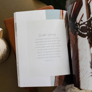 Open The Daily Grace Co. 'Worthy: embracing your identity in Christ' Devotional with text and a decorative illustrations on a Bible