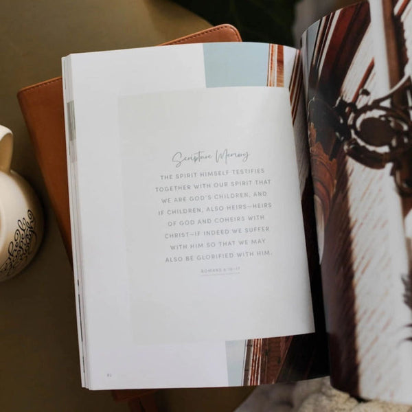 Open The Daily Grace Co. 'Worthy: embracing your identity in Christ' Devotional with text and a decorative illustrations on a Bible