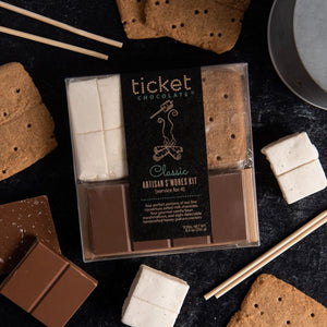 Ticket Chocolate s'mores kit with marshmallows, graham crackers, and chocolate bars on a dark surface.